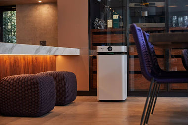 Alt Text: Airdog X8 Air Purifier in a modern living room, next to the kitchen counter