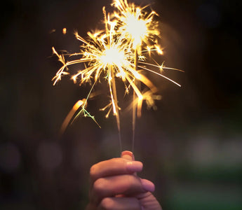 a hand holding a sparkler firework