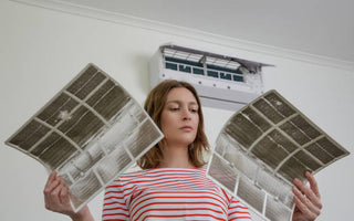 a lady holds 2 dirty air filters 